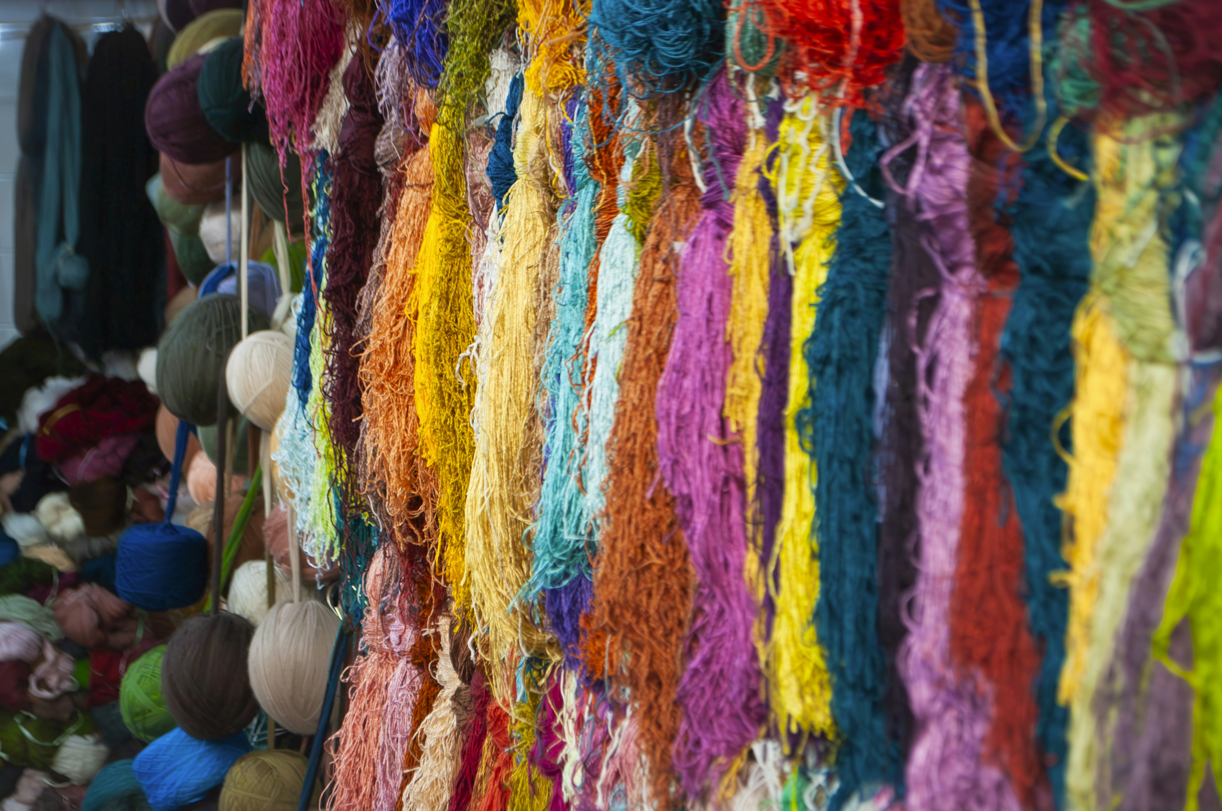 A bunch of colorful yarn hanging from a ceiling