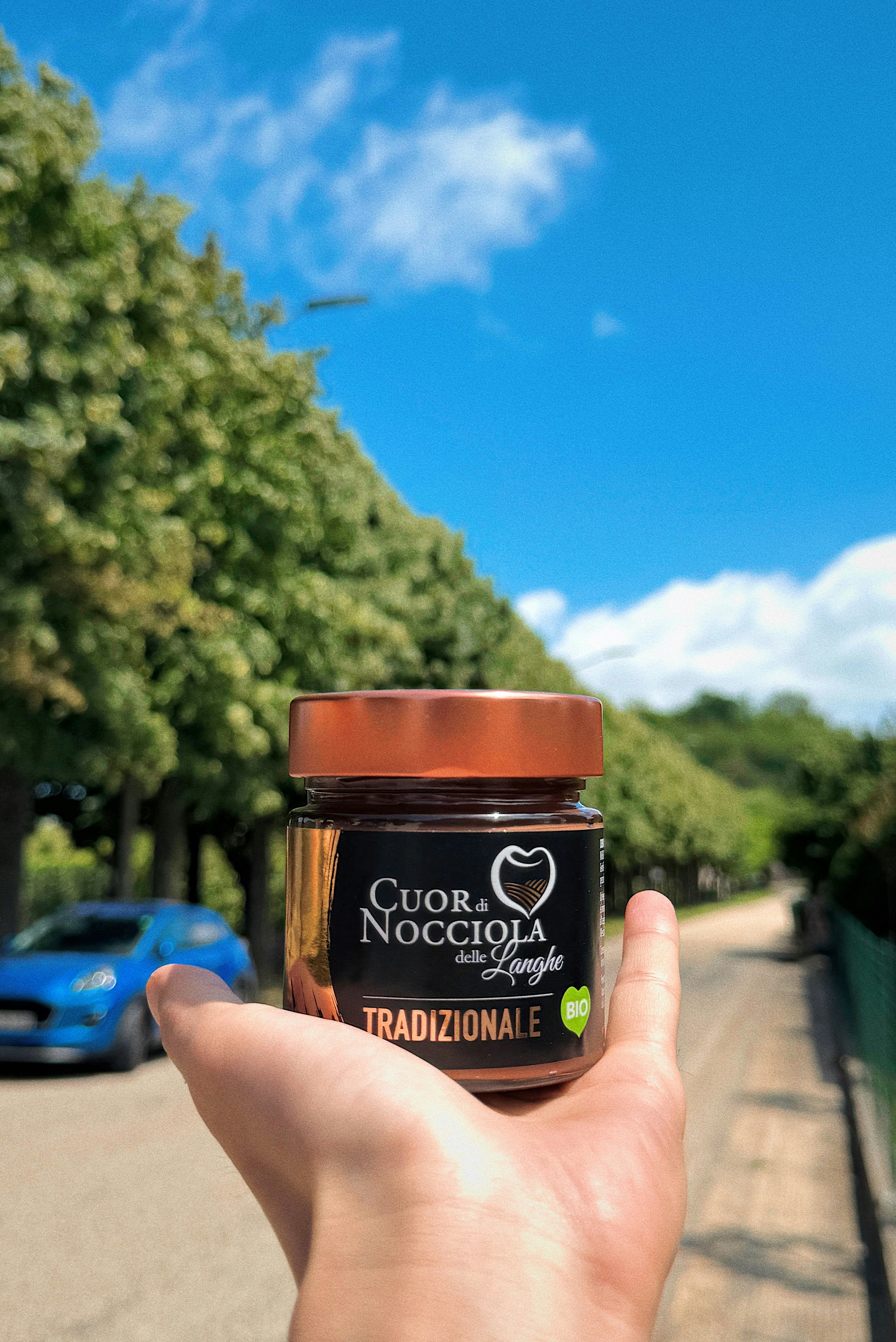 Rich hazelnut chocolate spread in a glass jar with hazelnuts scattered around, warm brown tones, soft lighting