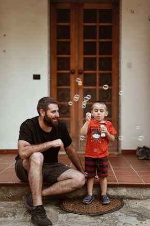 A man and a little boy blowing bubbles