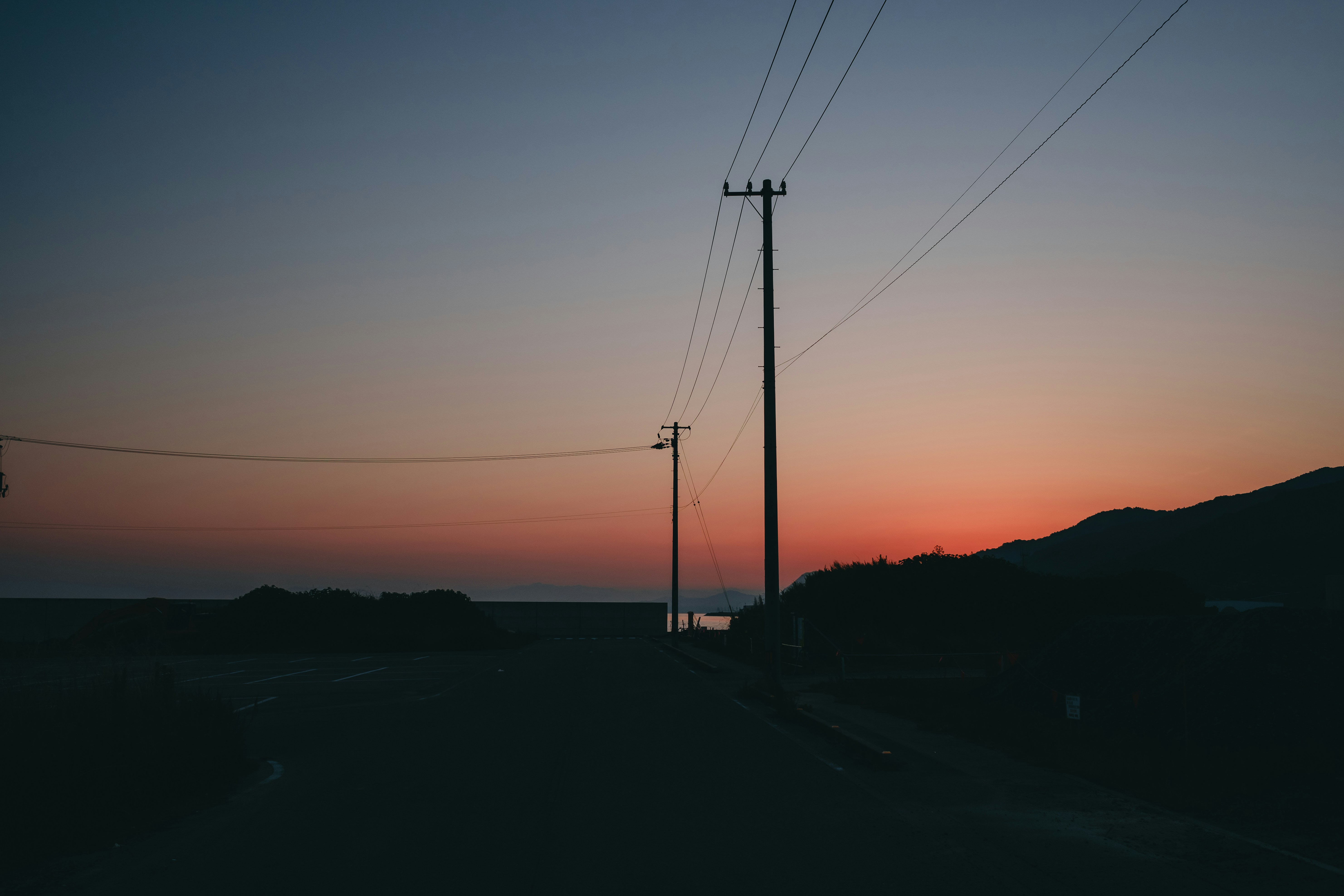 The sun is setting on the horizon of a road