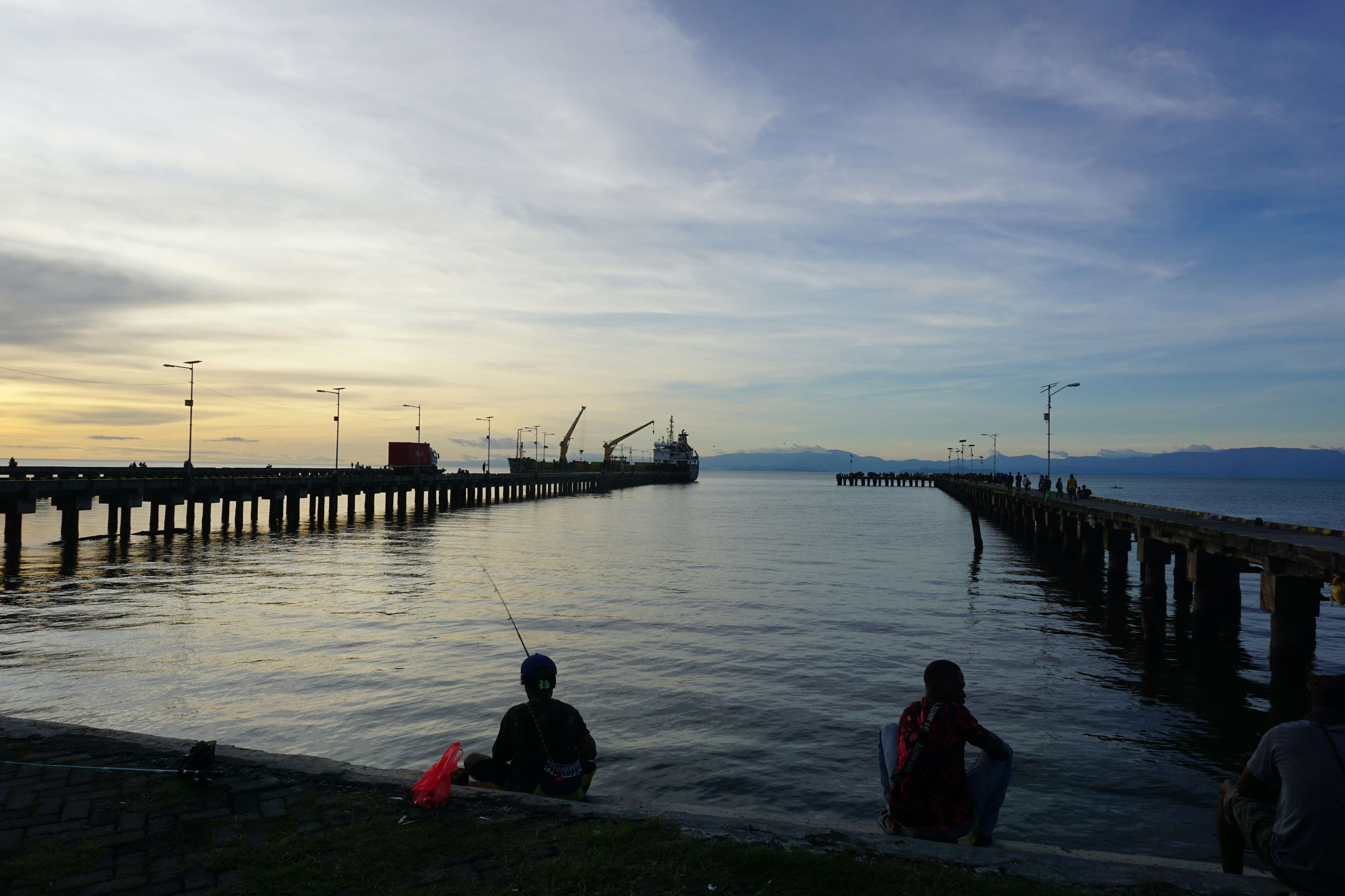 A group of people sitting next to a body of water