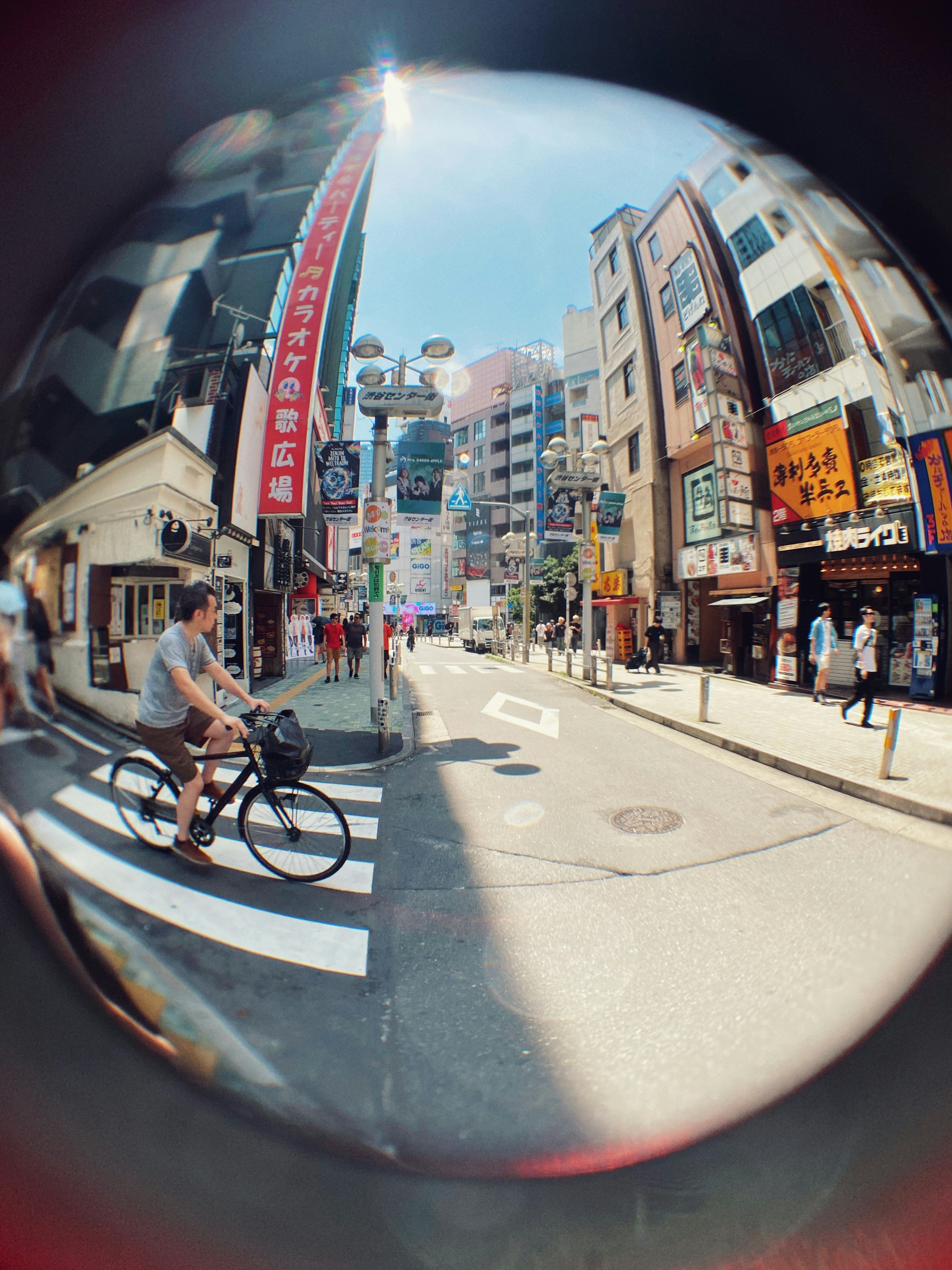 A man riding a bike down a street next to tall buildings