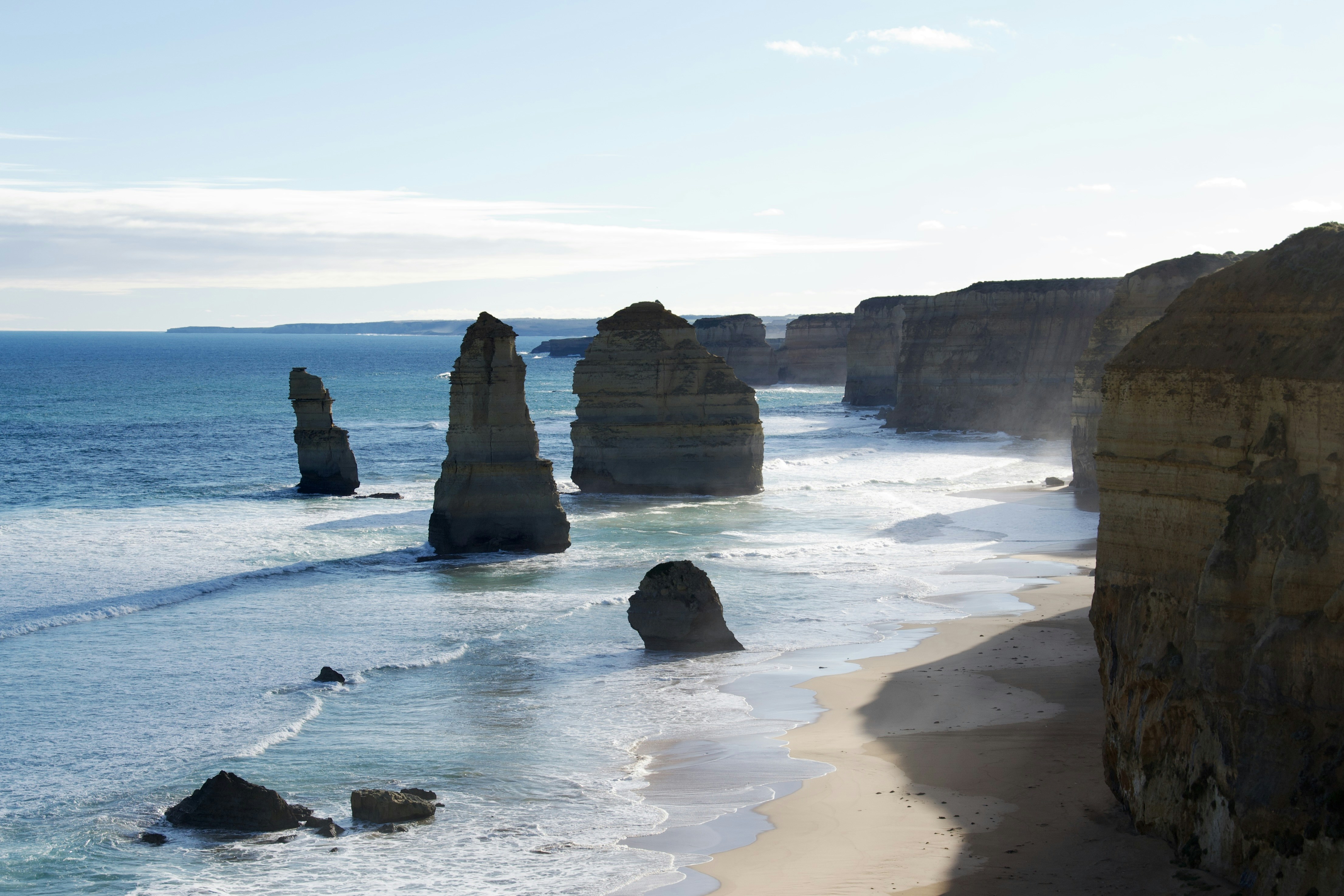 A view of a beach with some rocks in the water