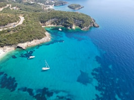 An aerial view of a beach with boats in the water