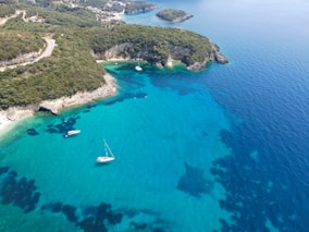 An aerial view of a beach with boats in the water