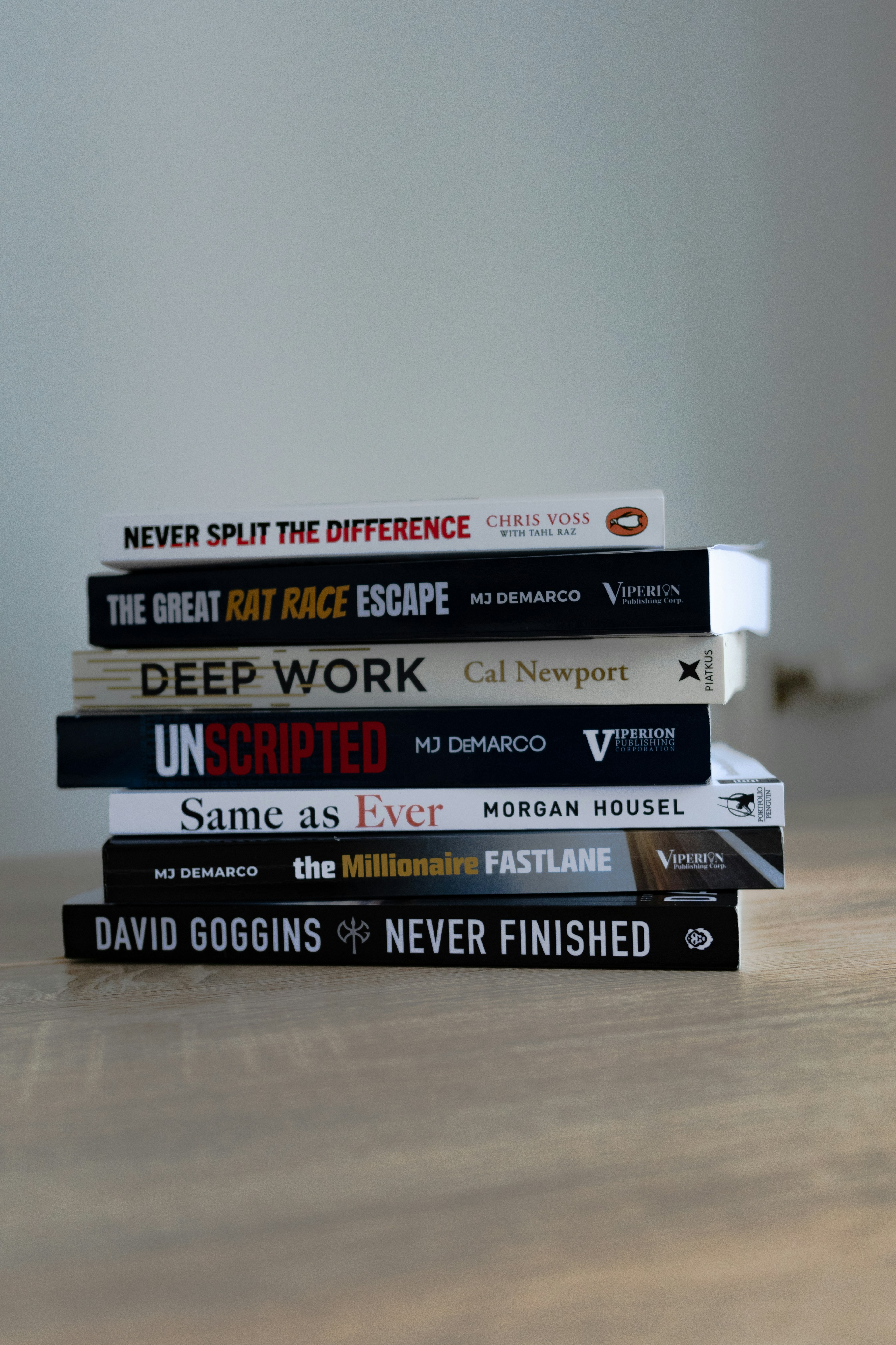 A stack of books sitting on top of a wooden table