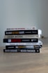 A stack of books sitting on top of a wooden table