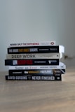 A stack of books sitting on top of a wooden table