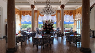 A large dining room with a chandelier hanging from the ceiling
