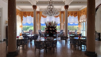 A large dining room with a chandelier hanging from the ceiling