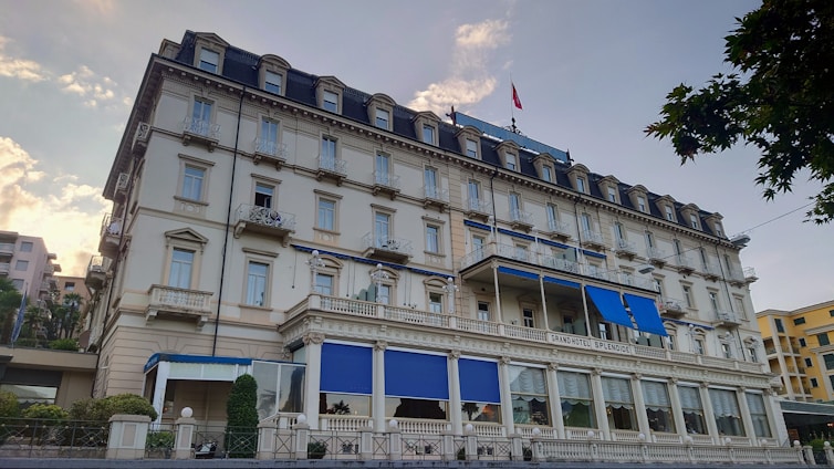 A large hotel building with blue shutters and windows