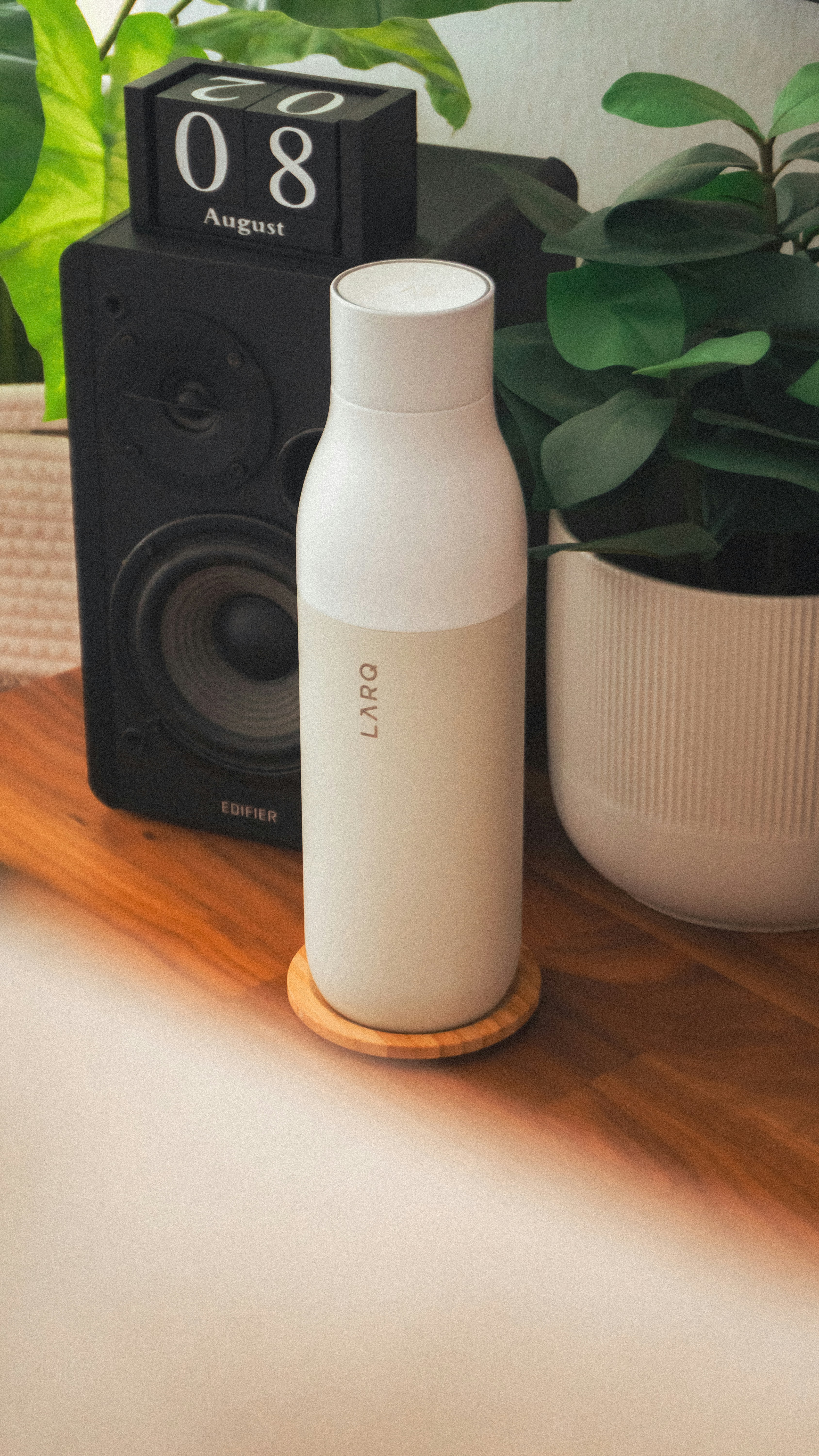 A white bottle sitting on top of a wooden table