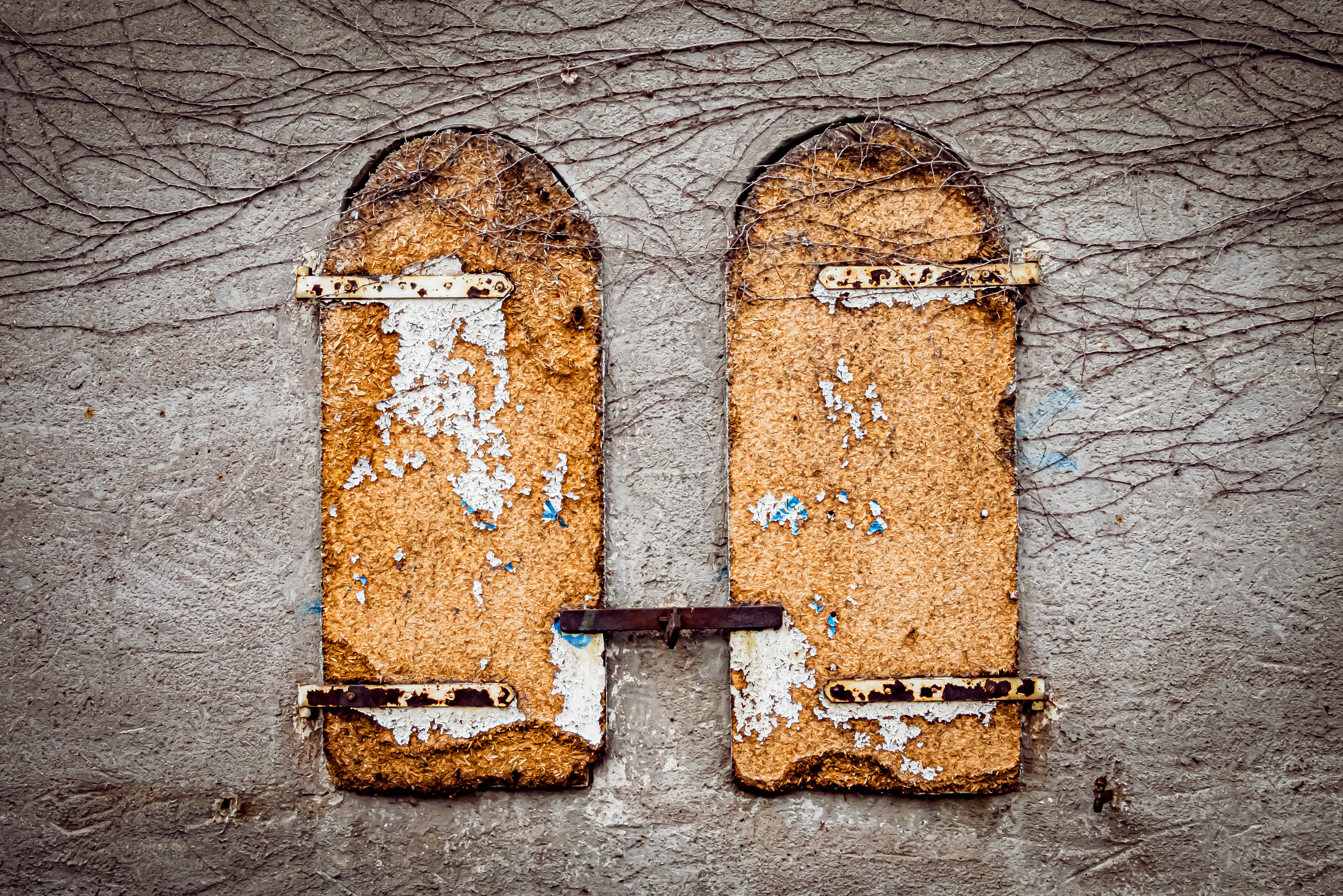 A pair of broken windows sitting on top of a cement wall
