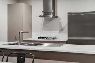 A kitchen with a stove, sink, and refrigerator