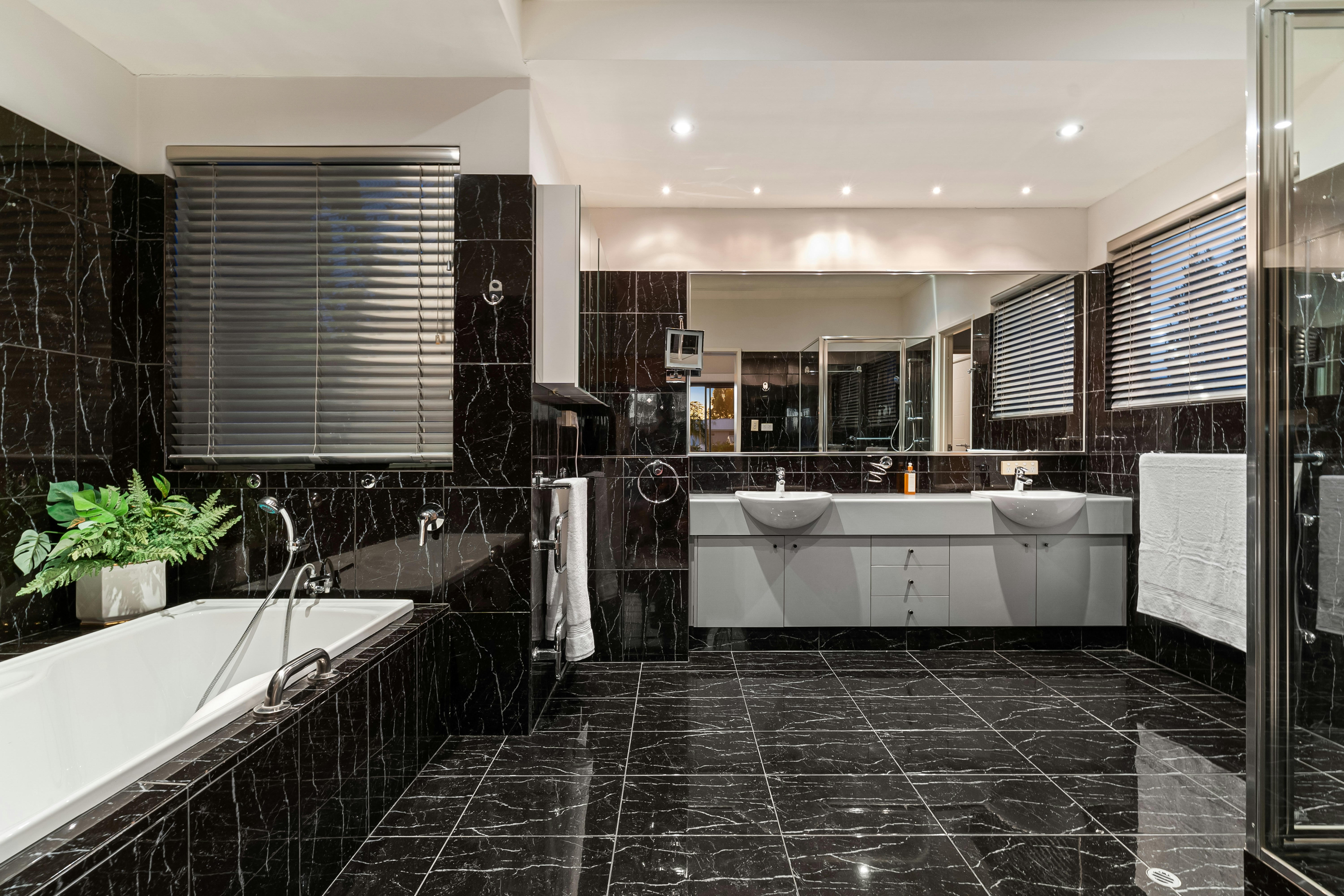A black and white bathroom with a tub and sink