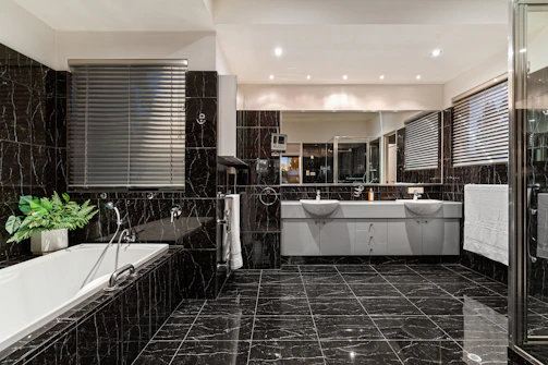 A black and white bathroom with a tub and sink