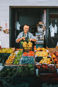 A man standing in front of a fruit stand