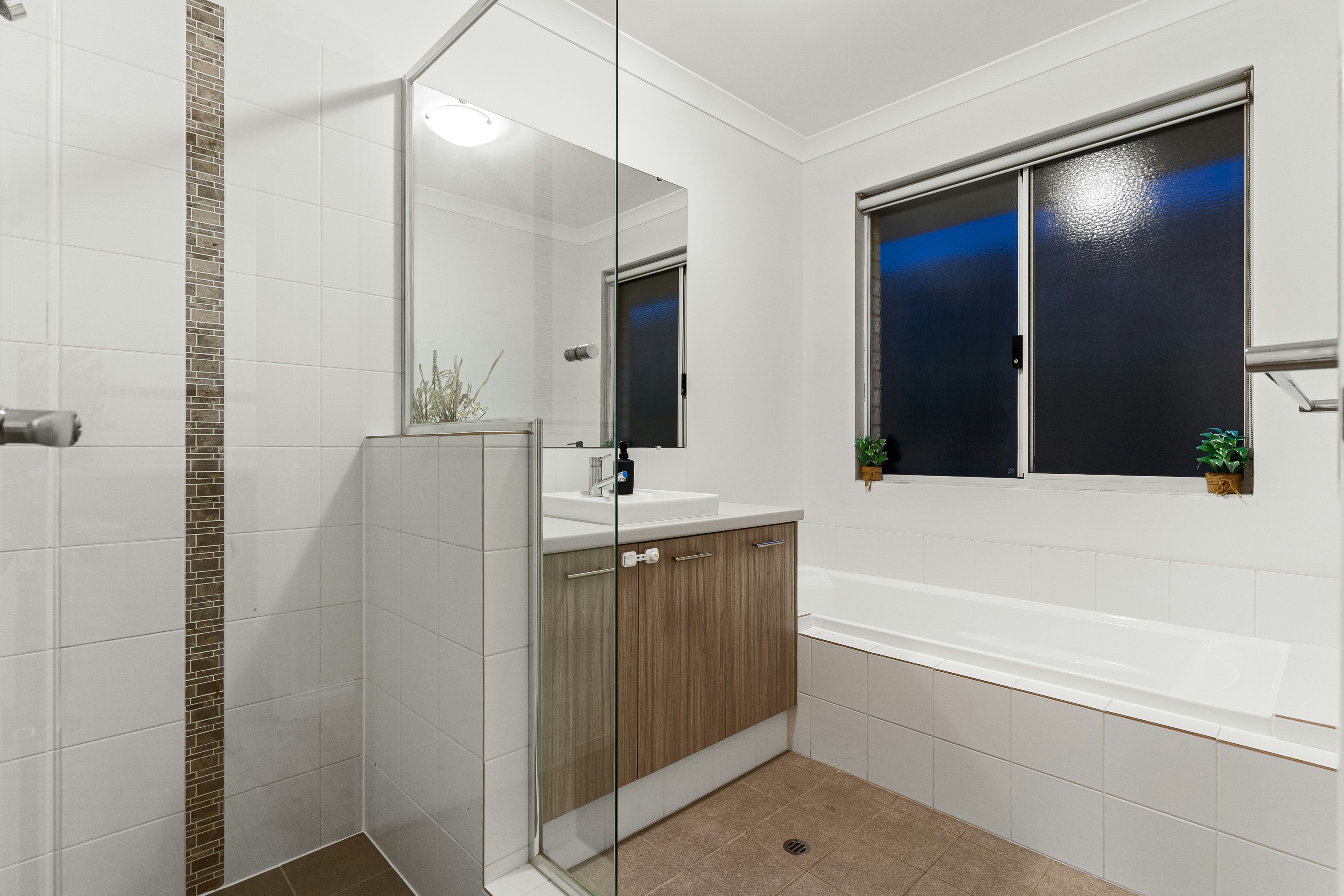 A bathroom with a walk in shower next to a sink