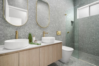 A bathroom with two sinks, a toilet and a shower