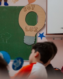 A group of children standing in front of a blackboard