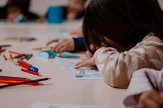 A group of children sitting at a table with pencils