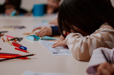 A group of children sitting at a table with pencils