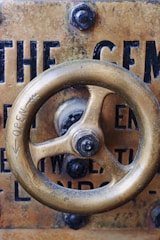A close up of a metal object with a steering wheel