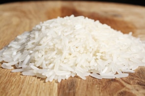 A pile of rice sitting on top of a wooden cutting board