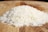 A pile of rice sitting on top of a wooden cutting board