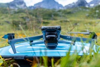 A camera sitting on top of a surfboard in the grass