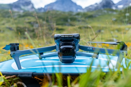 A camera sitting on top of a surfboard in the grass