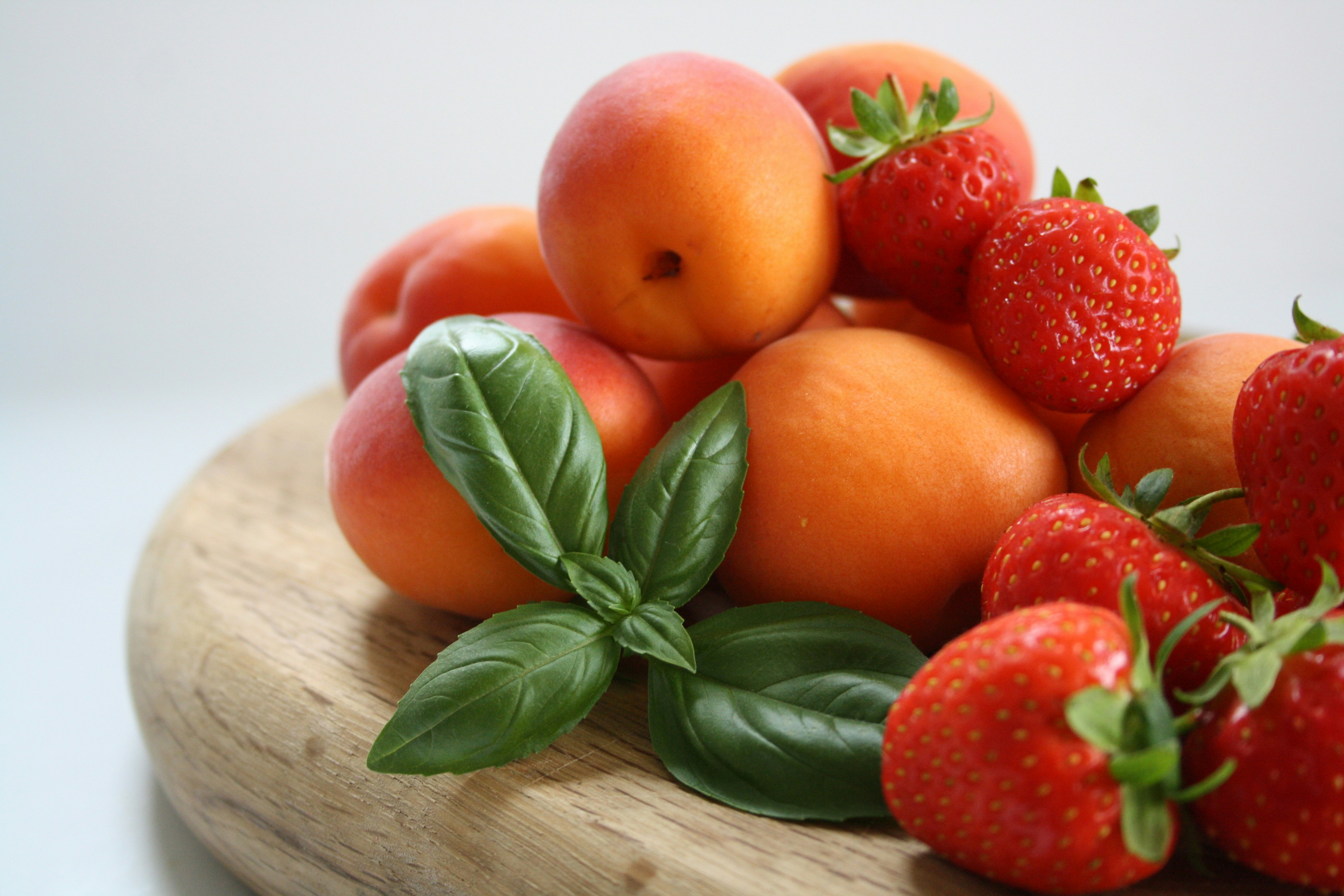 A pile of fresh fruit sitting on top of a wooden plate