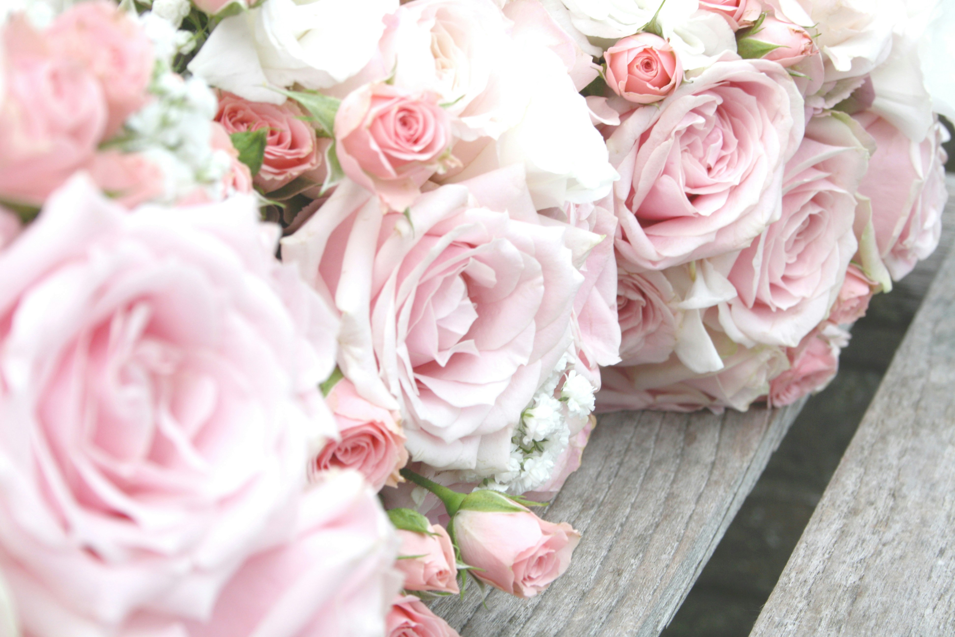 A bouquet of pink and white flowers on a bench