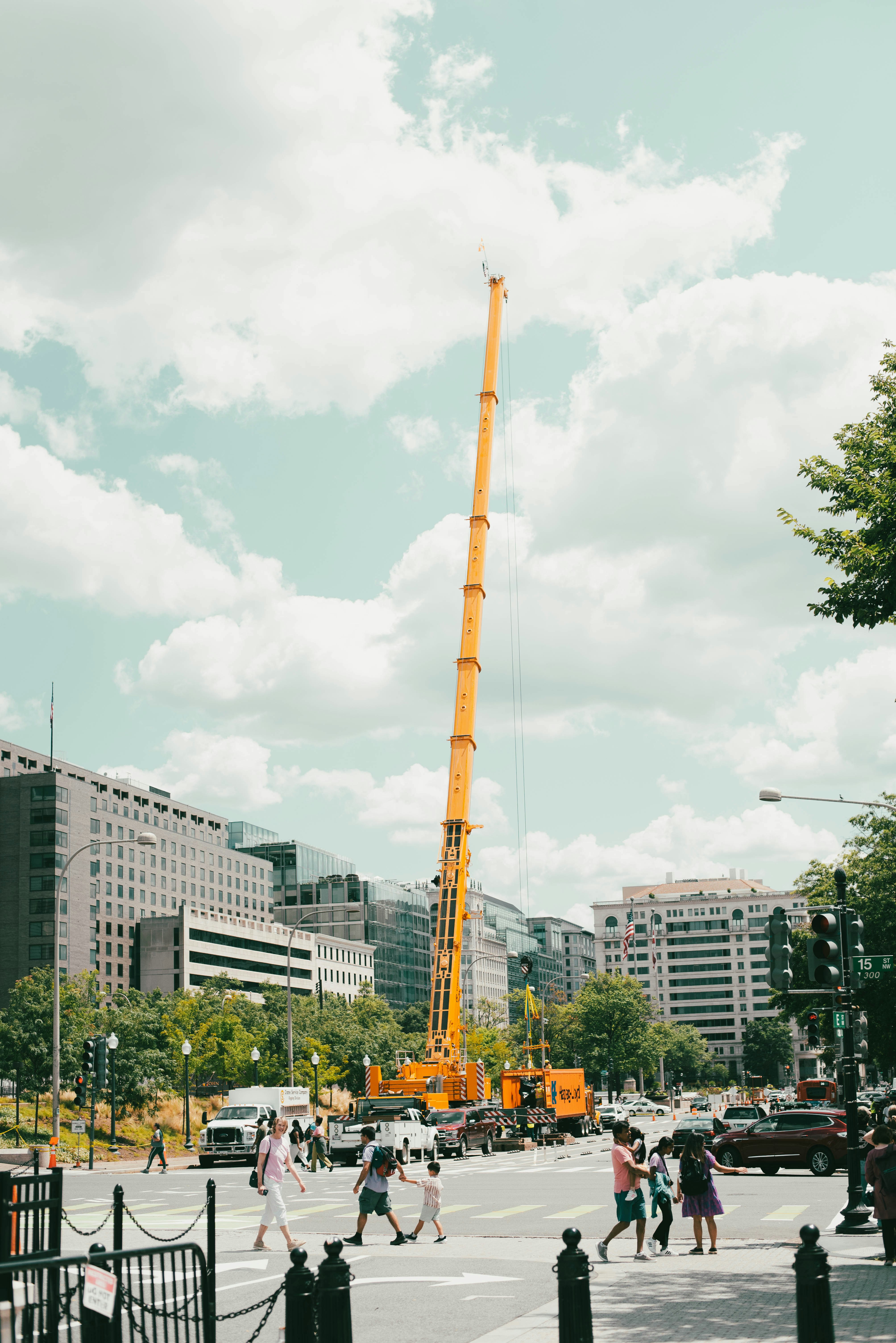 A busy city street with a tall yellow crane in the background