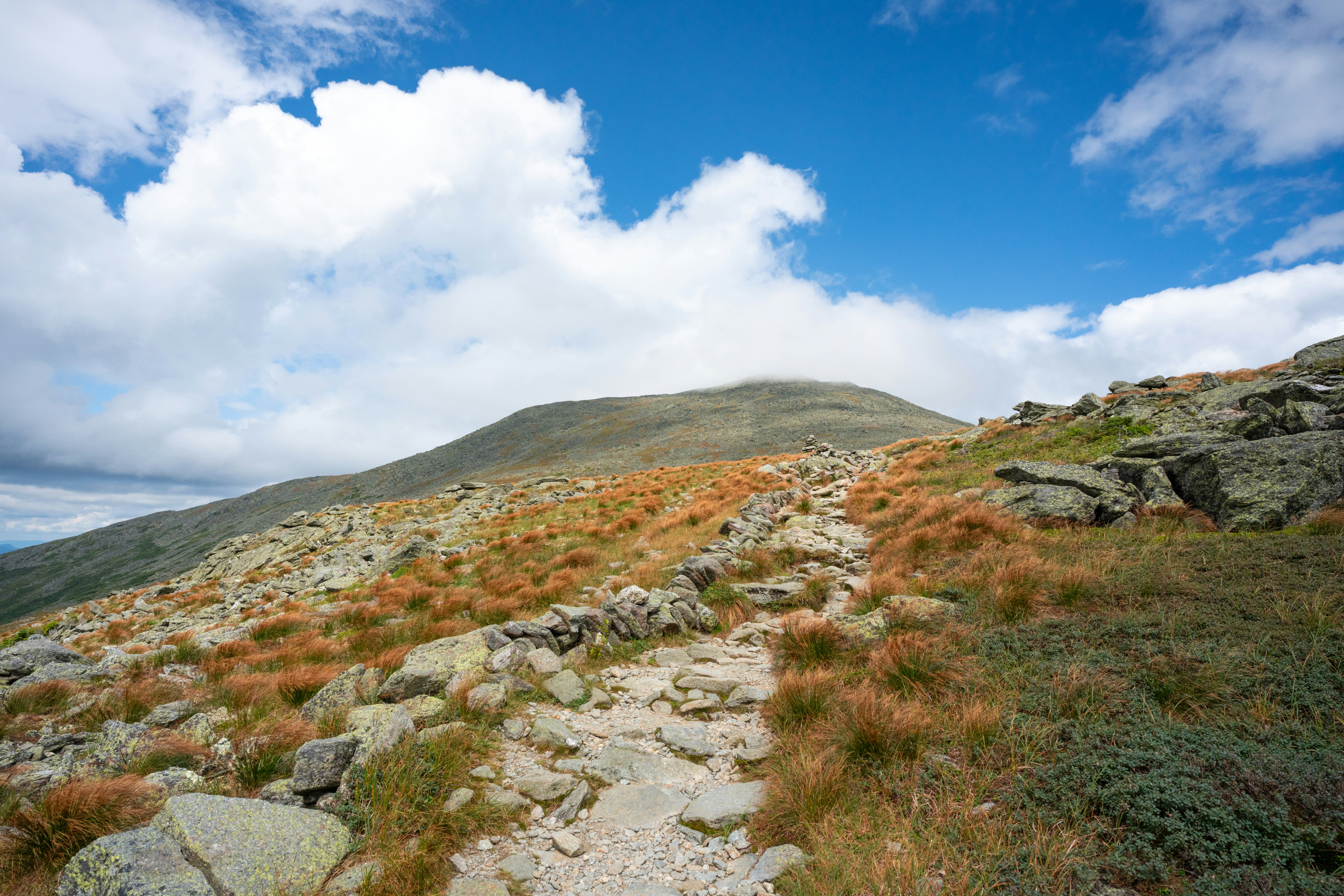 A rocky mountain with grass and rocks on it