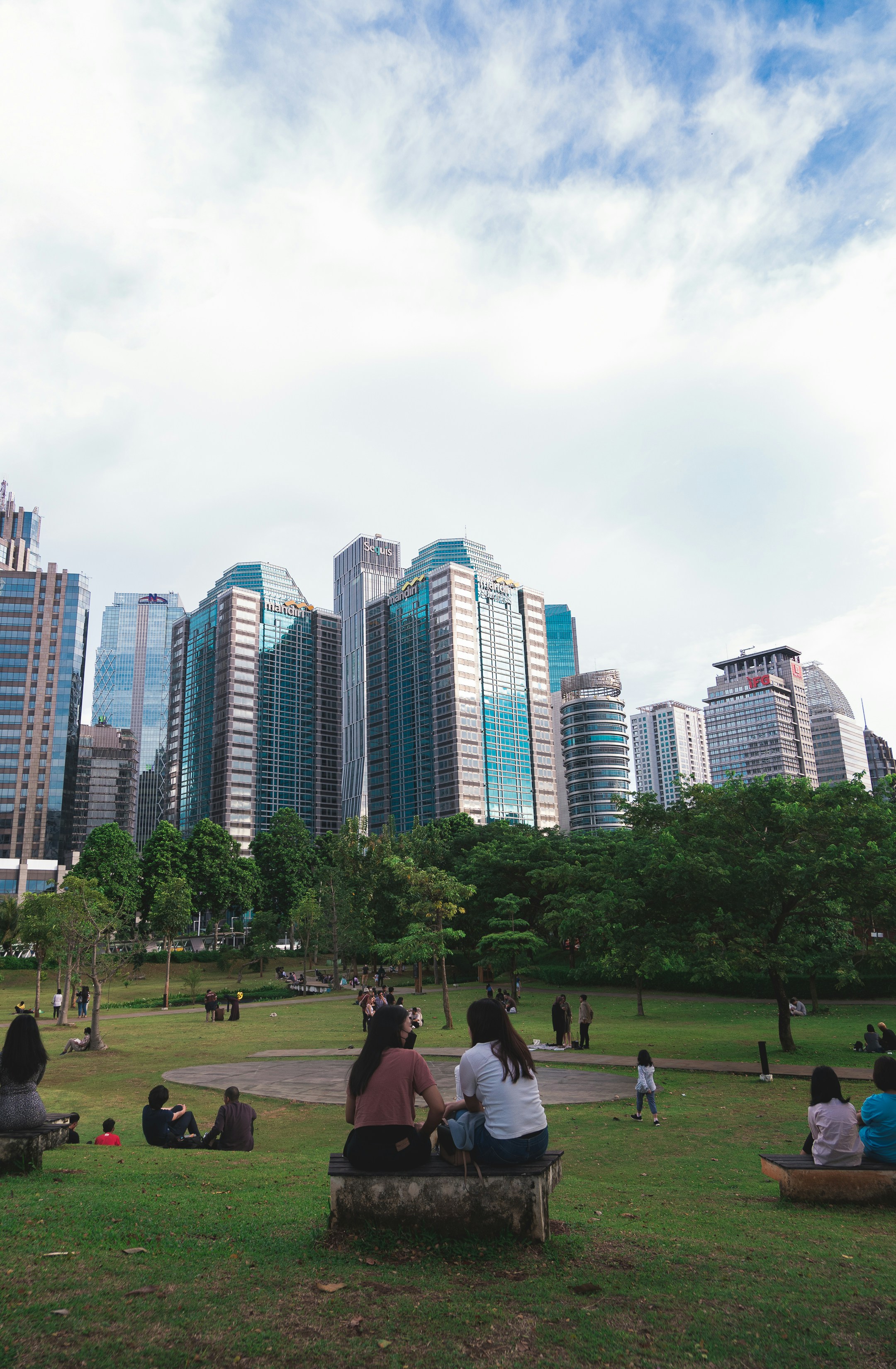 A group of people sitting on top of a lush green field