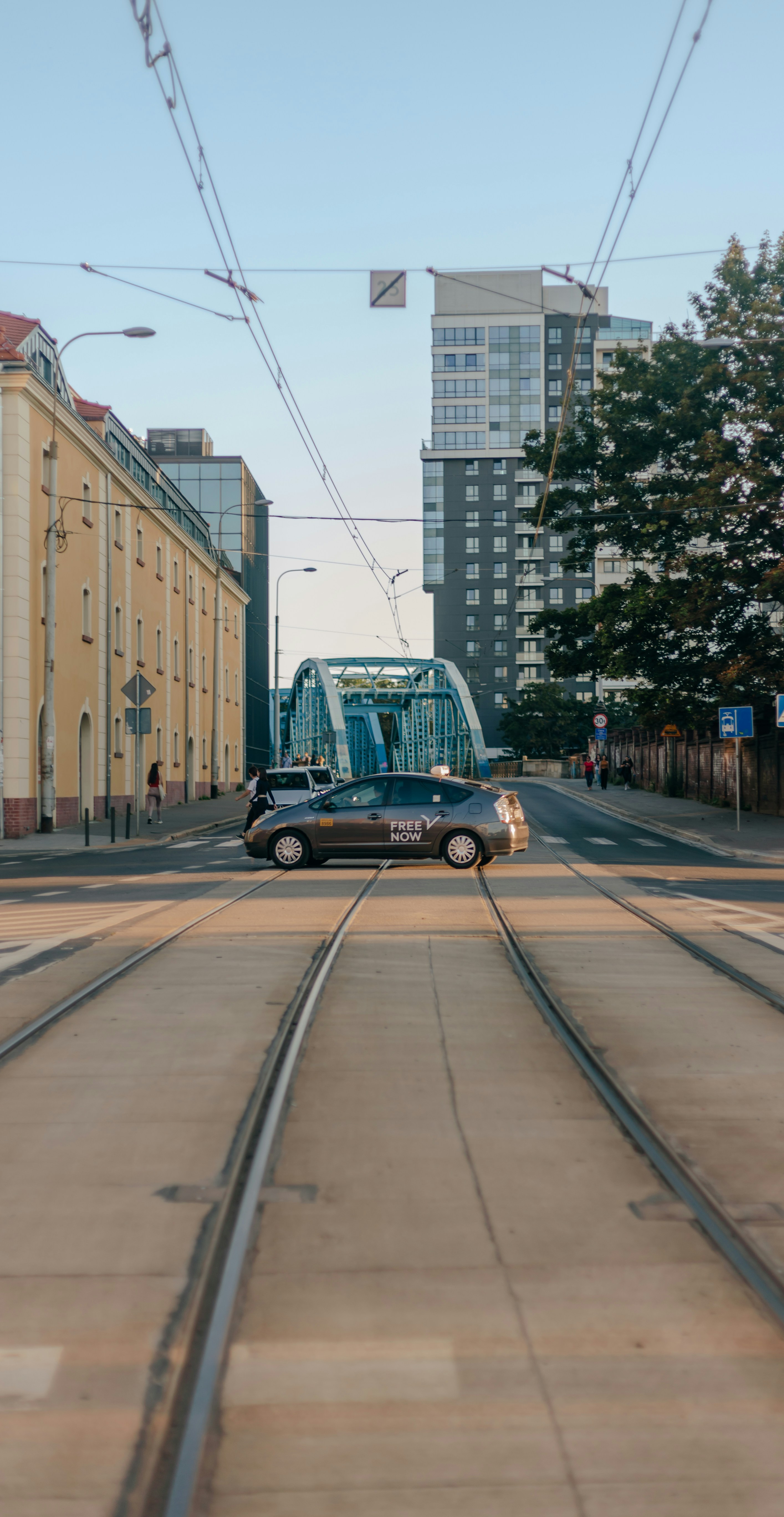 A car driving down a street next to a train track