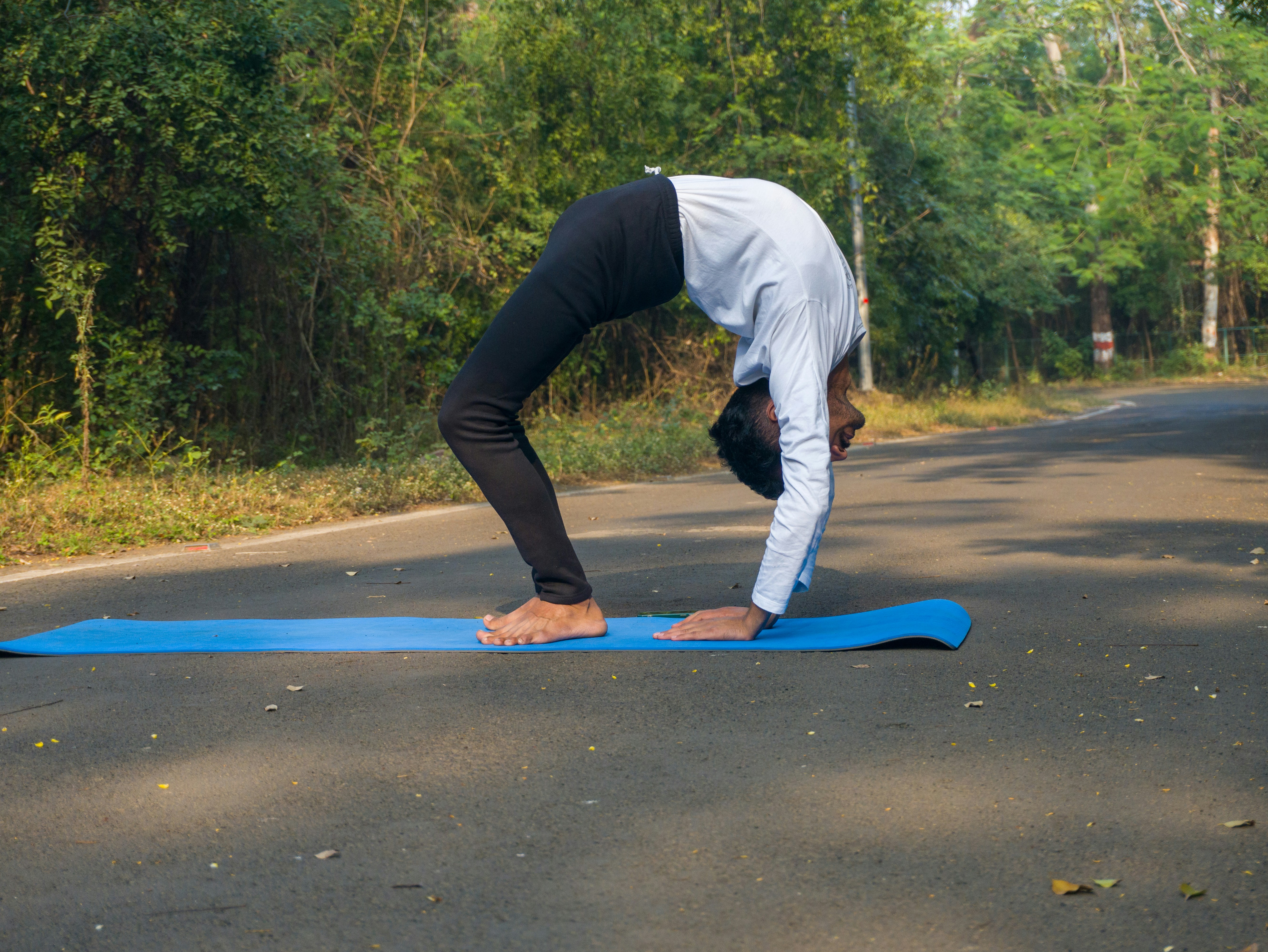 Man performing glute bridge on exercise mat, hips raised, athletic wear, bright gym
