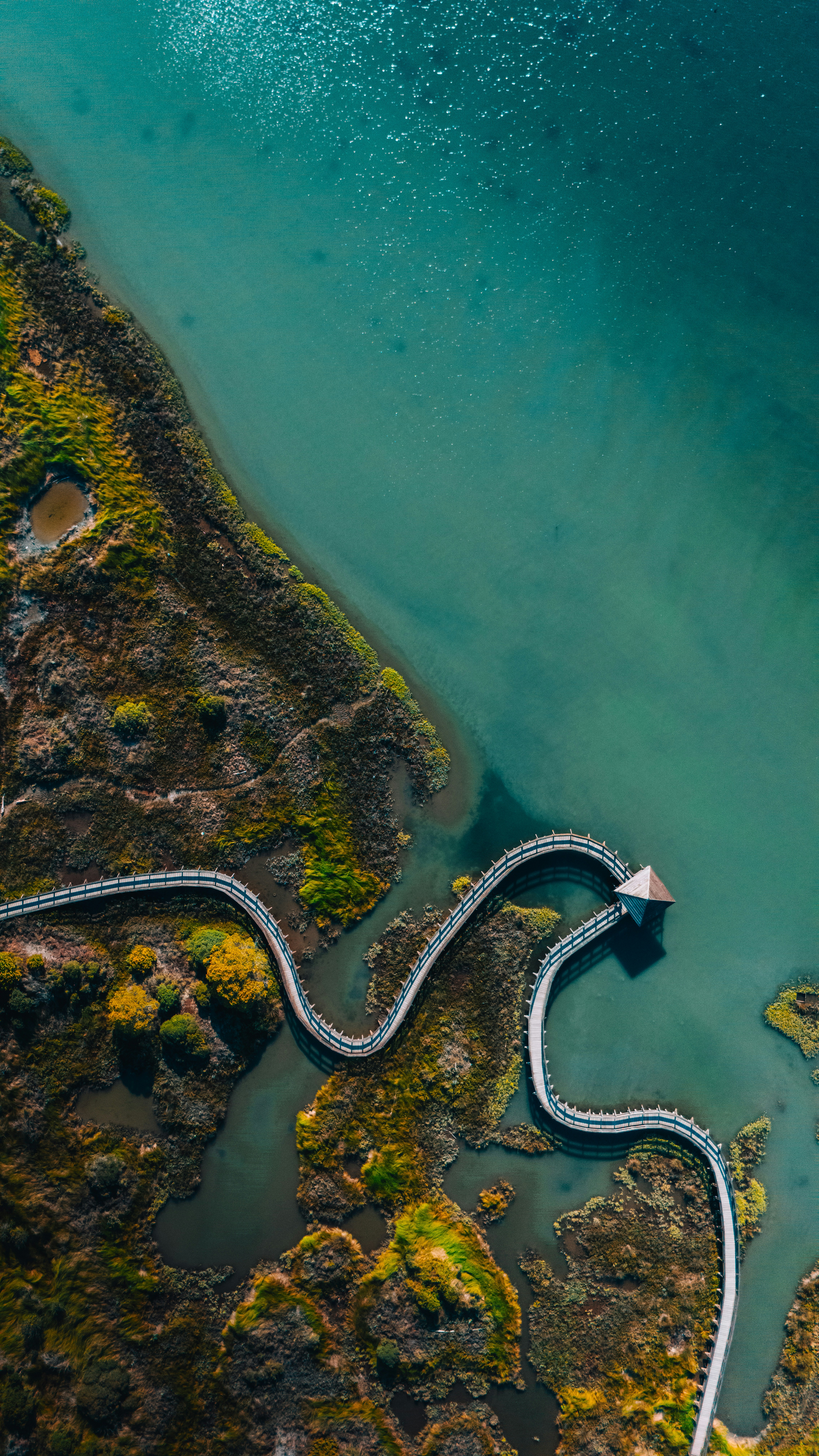 An aerial view of a winding road next to a body of water
