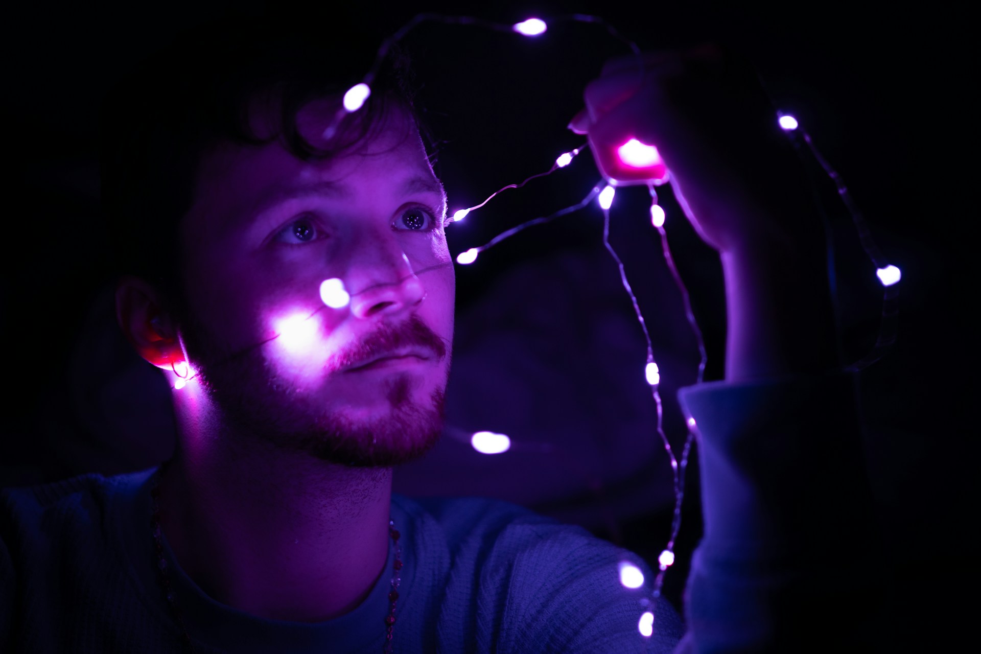 A man holding a string of lights in his hand