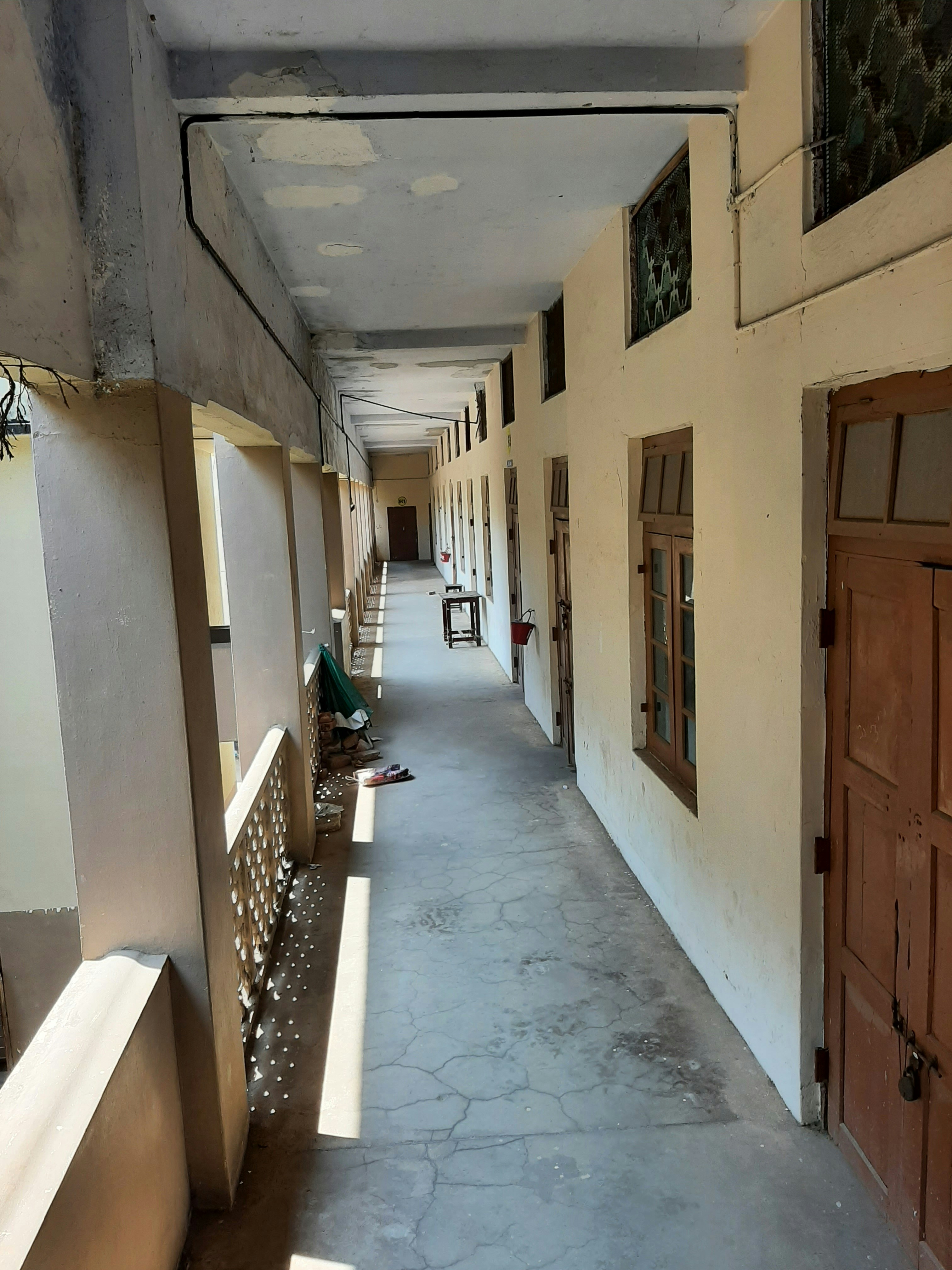 A long hallway with several doors and windows