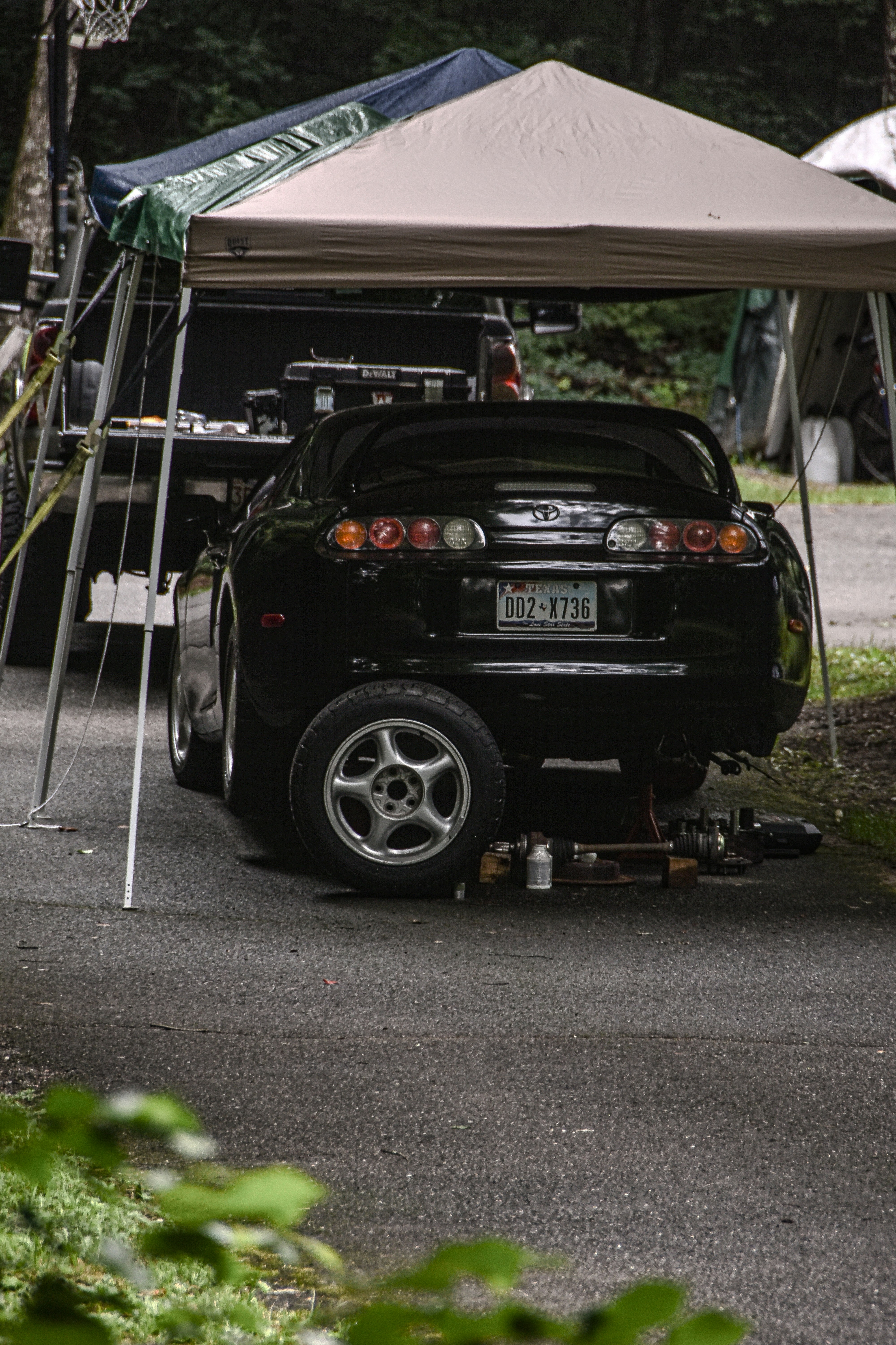 A car is parked under a tent in the woods photo – Free Machine Image on ...