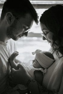 A man and a woman are holding a baby