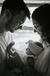A man and a woman are holding a baby