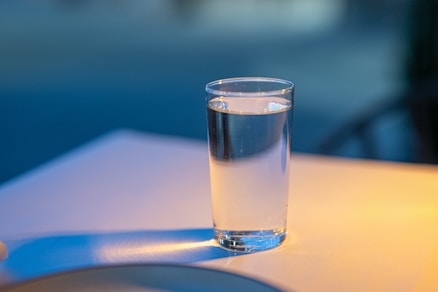 A glass of water sitting on top of a table