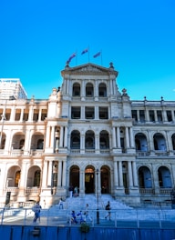 A large white building with flags on top of it