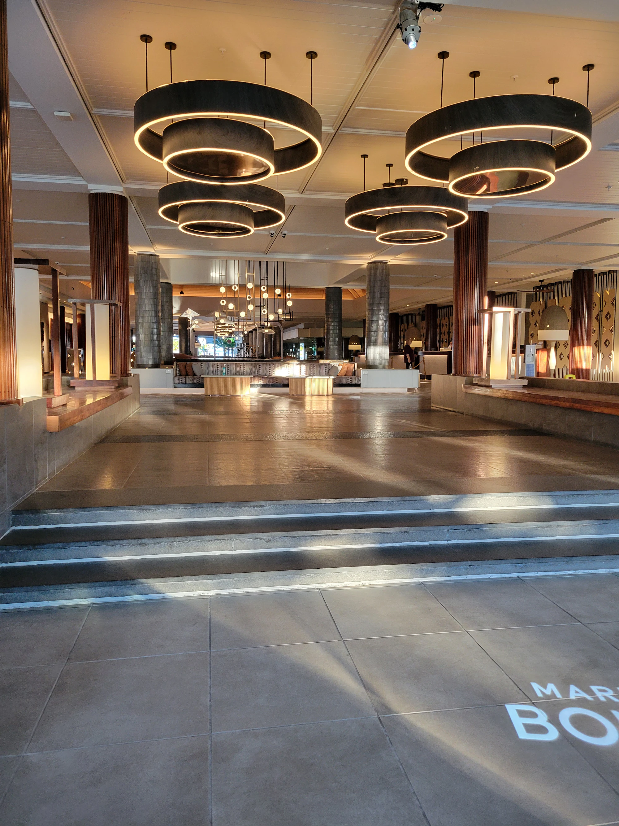 A boutique hotel reception at night, lamps lit, the desk quiet.