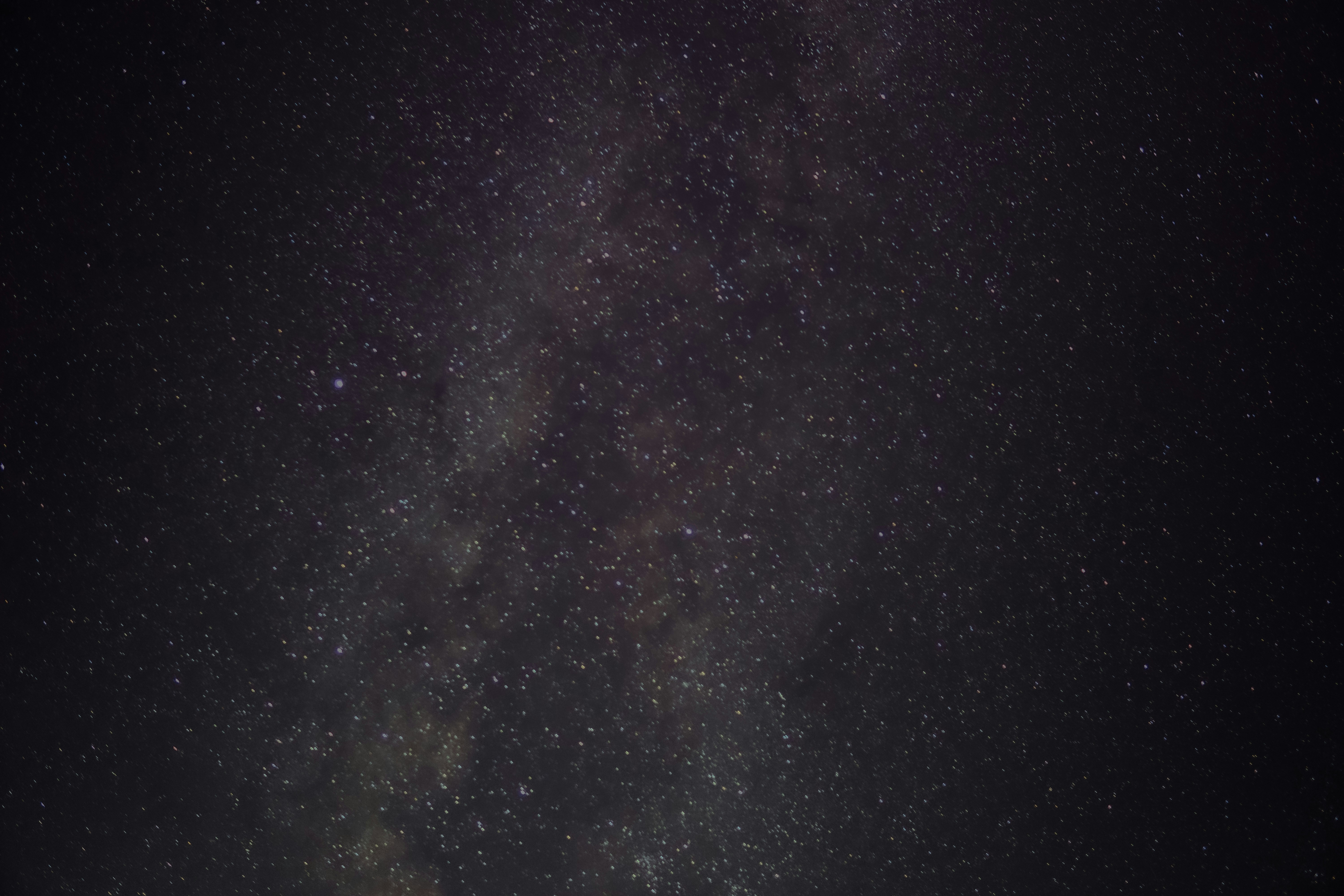 The night sky is filled with stars and clouds