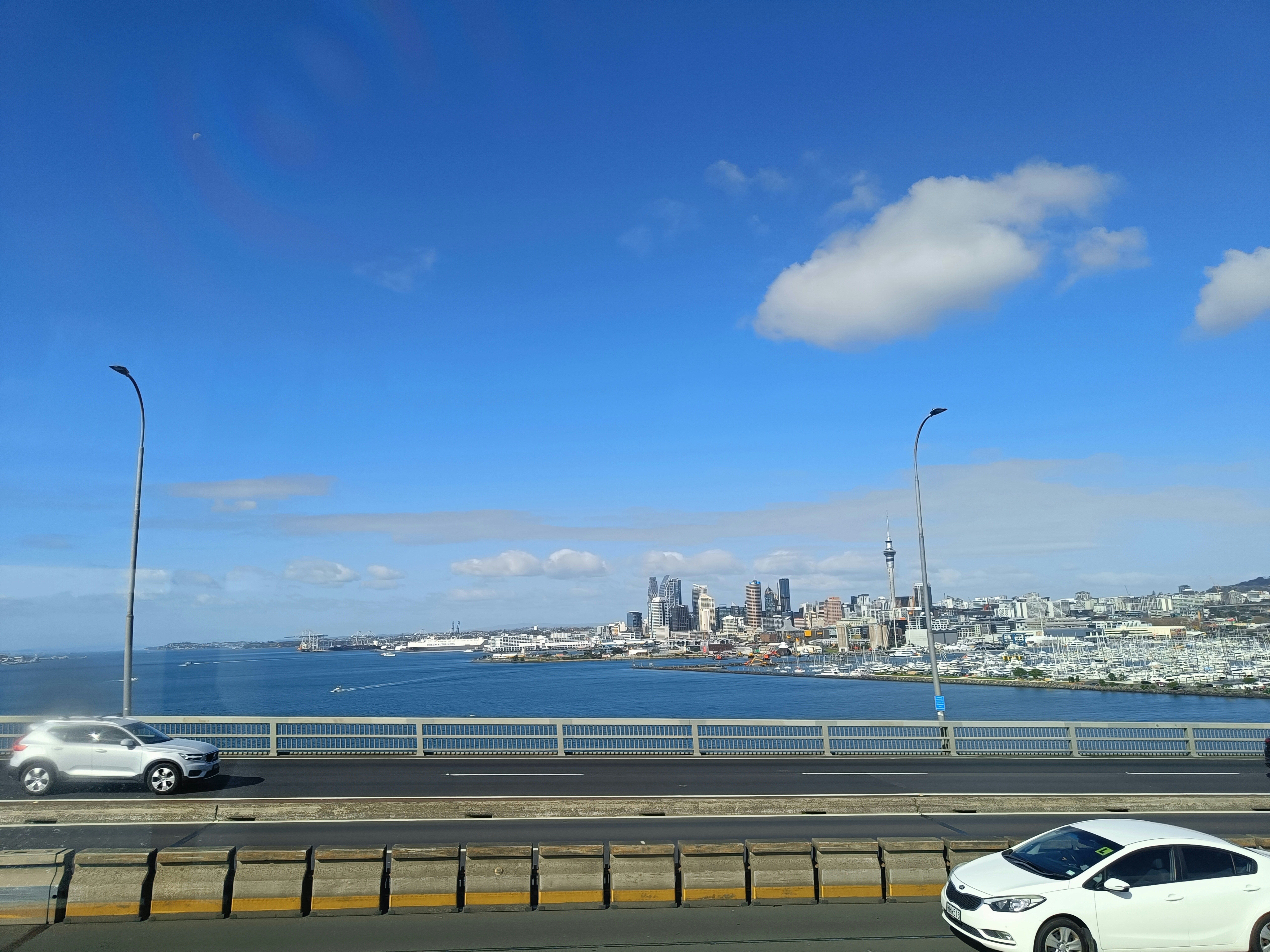 A white car driving down a highway next to a body of water