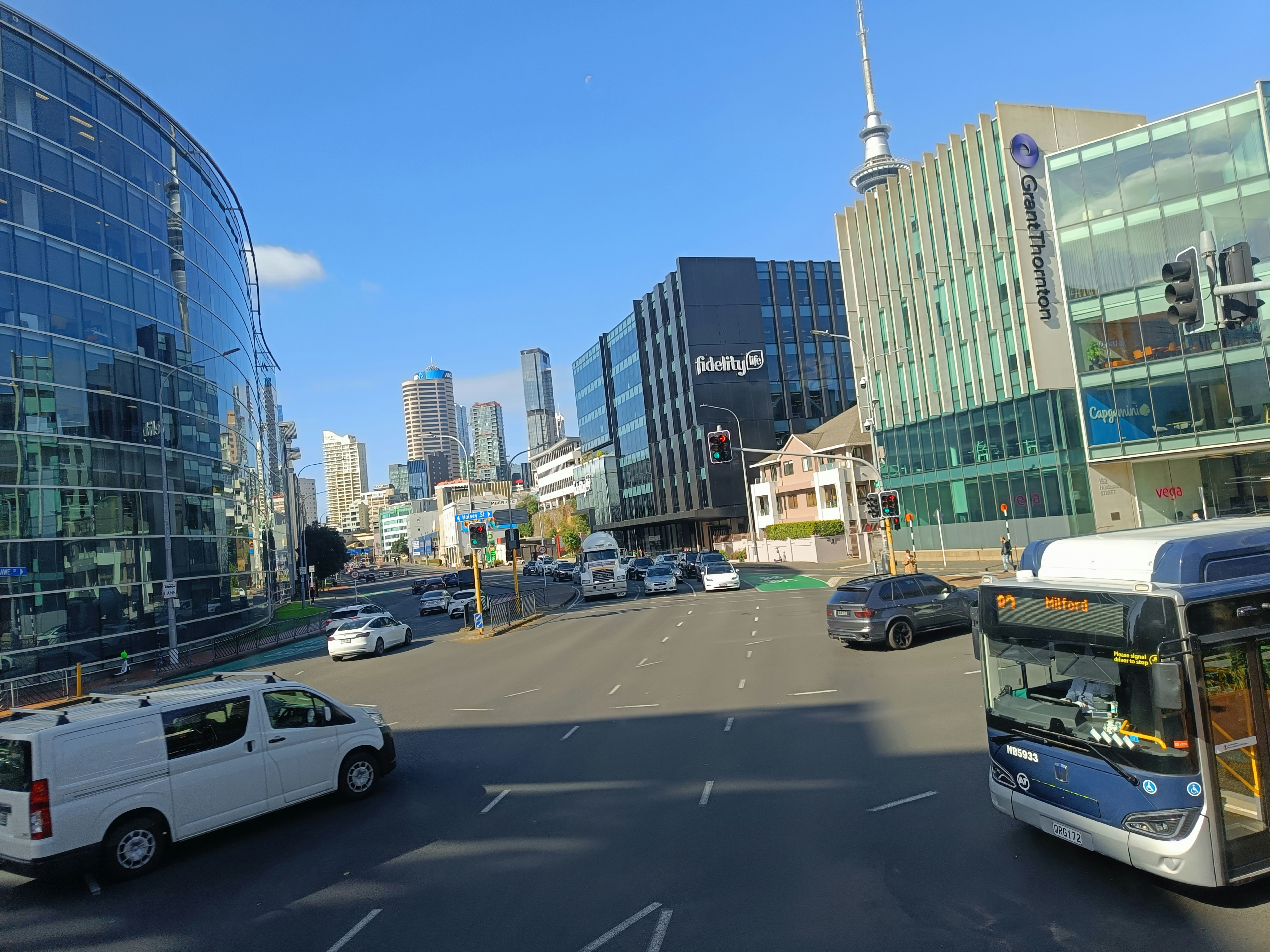 A city street filled with traffic next to tall buildings